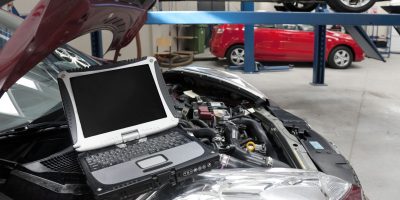 car-in-a-workshop-and-a-computer-running-diagnosti-2023-11-27-05-04-53-utc